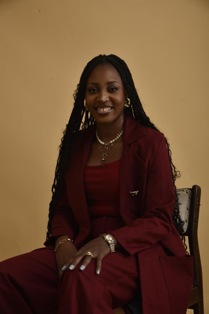 Portrait of Priscilla wearing a wine-coloured suit