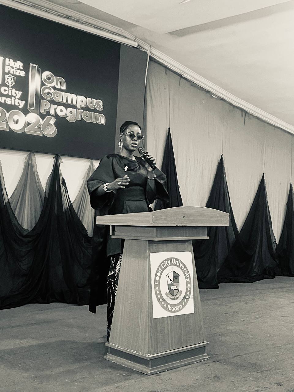 Priscilla speaking from a lectern